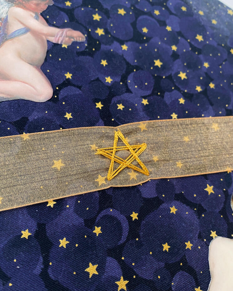 Gold thread detailing, securing ribbon closure to the book cover.